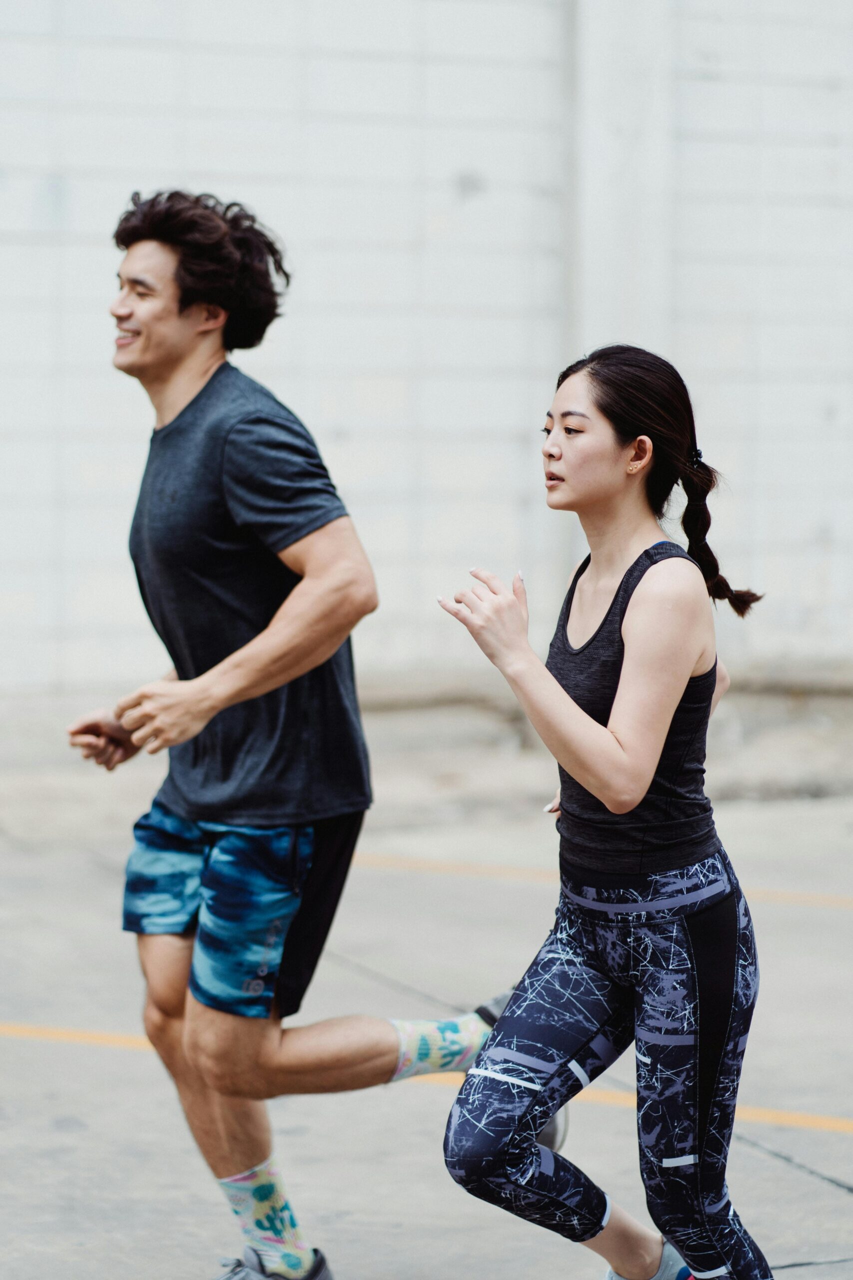 A man and a woman running outdoors, promoting fitness and a healthy lifestyle.